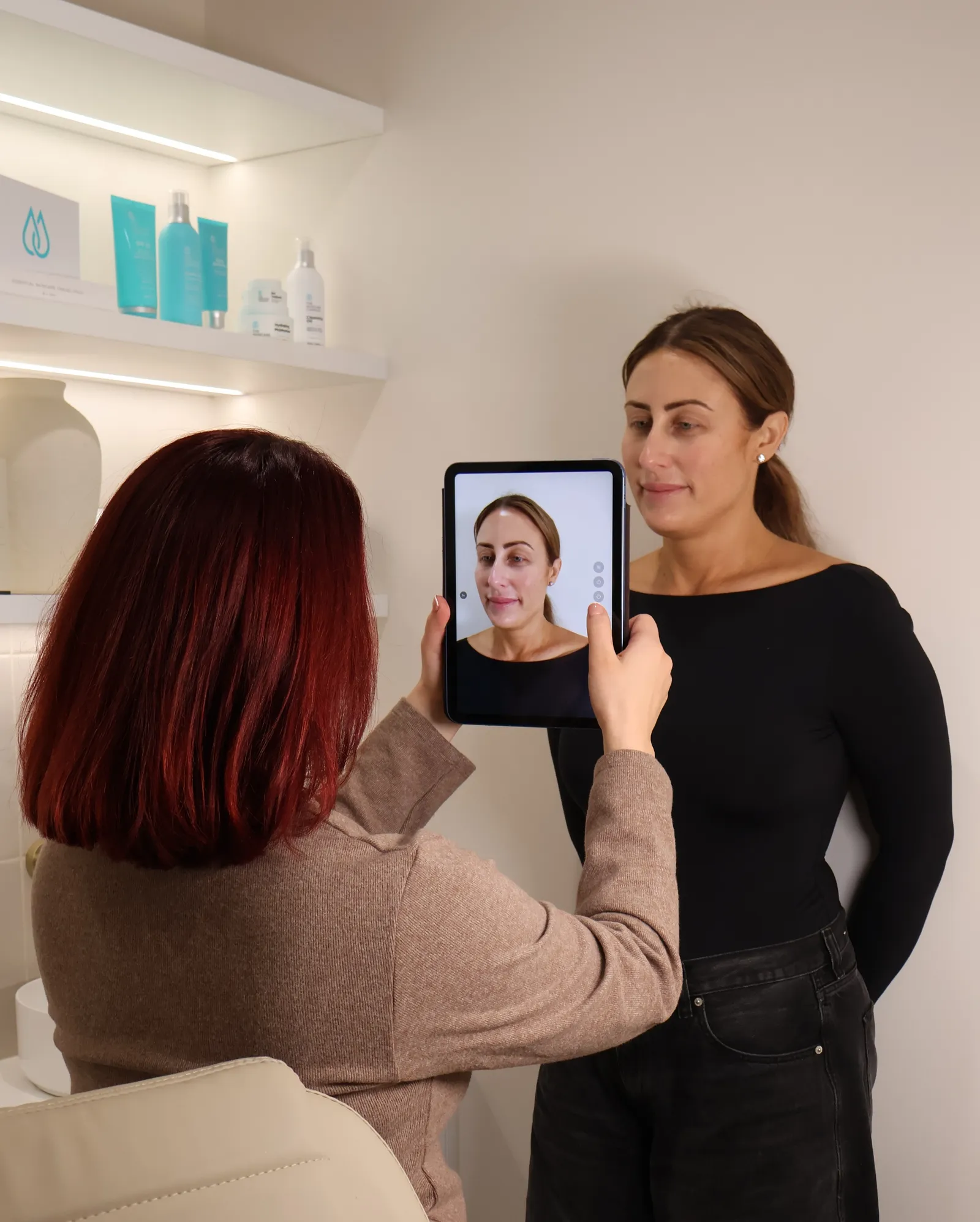 Stephanie reviewing clinical photographs on a tablet with a client at Saint Kaliya.
